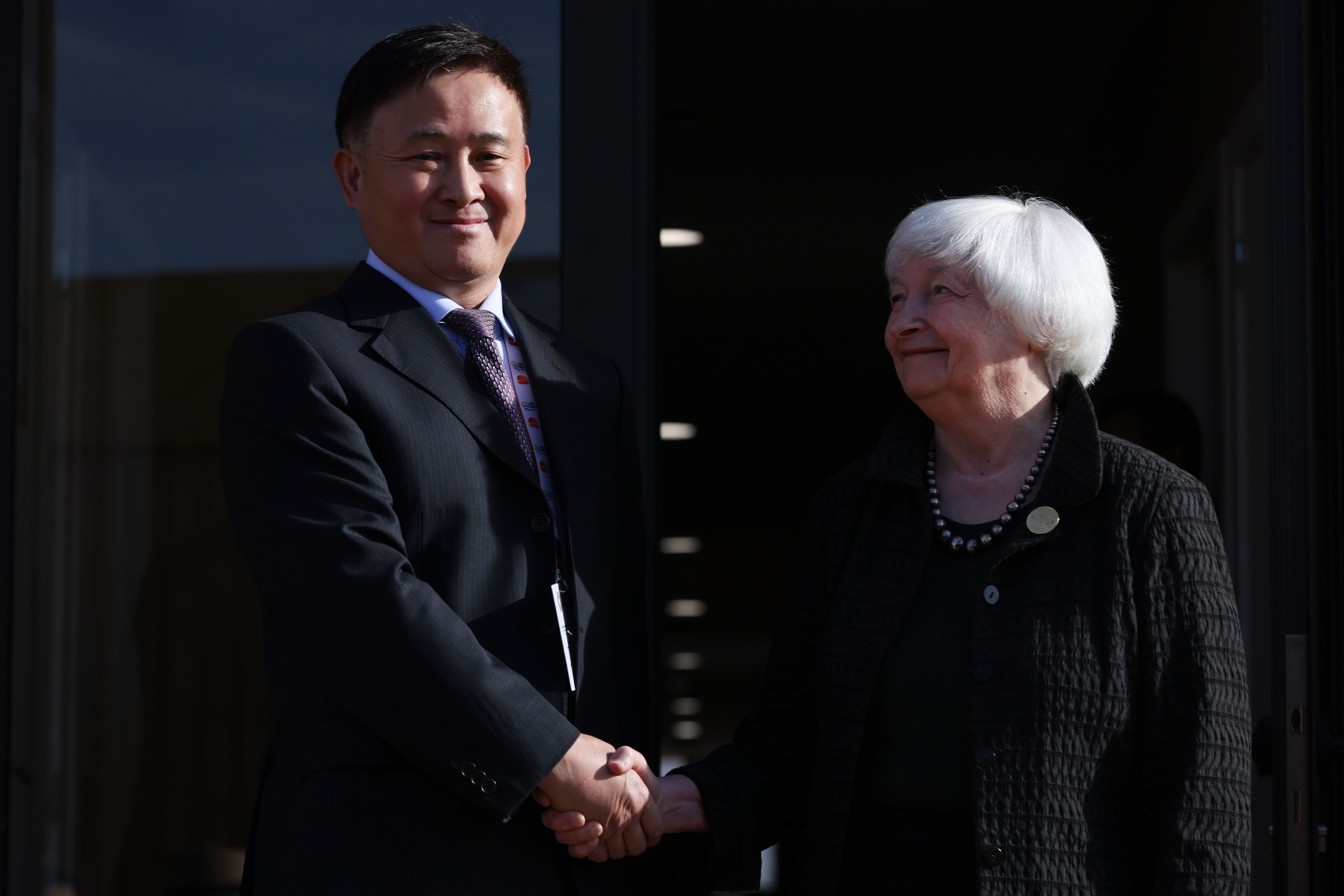 Pan Gongsheng, governor at the People&rsquo;s Bank of China (PBOC), shakes hands with Janet Yellen